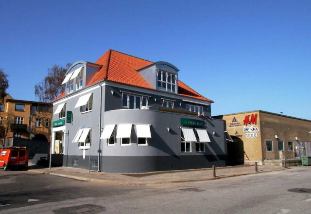 Jyske Bank på Madevej i Aabenraa fik i 1999 facaderenovering med fleksibel maling og udvendig isolering. Udført af Malerfirma Koch.