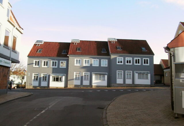 Facaderenovering 2000 af rækkehuse i Aabenraa. Grunding, reparation og maling af pudset facade for langvarig beskyttelse.